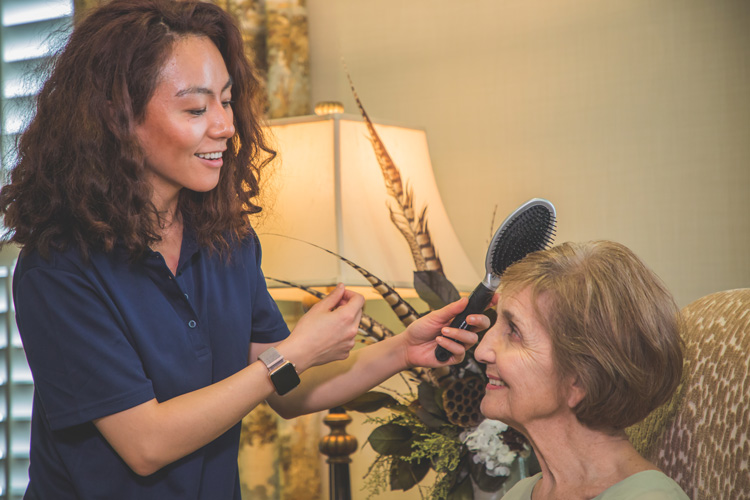 Employee brushing woman's hair